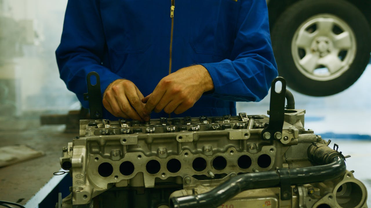 Close-up of a mechanic repairing an engine in a garage setting.